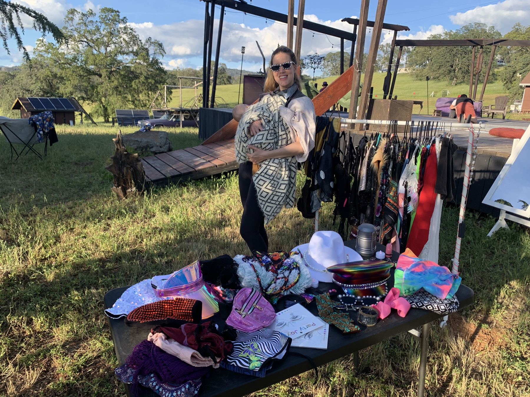 Me at my market stall, hand-decorated hats and accessories laid out on the table